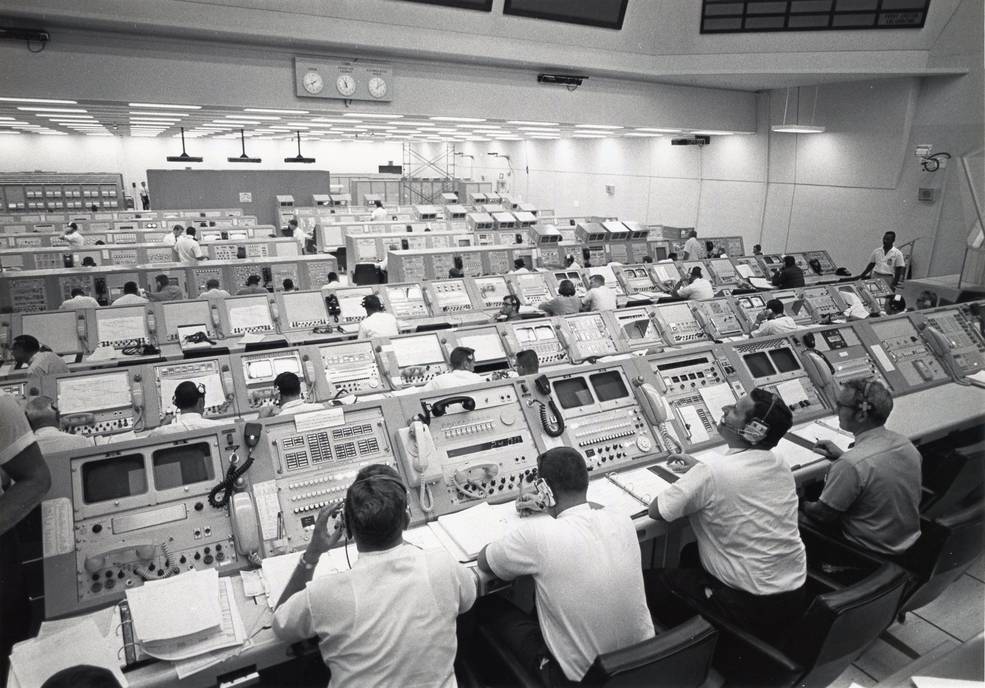 Historical photograph H4. Engineers monitor an Apollo 11 vehicle test in Launch Control Center Firing Room 1, 1969. Rows of staffed consoles make the distribution of observation and responsibility visible. NASA, KSC-69P-3253.